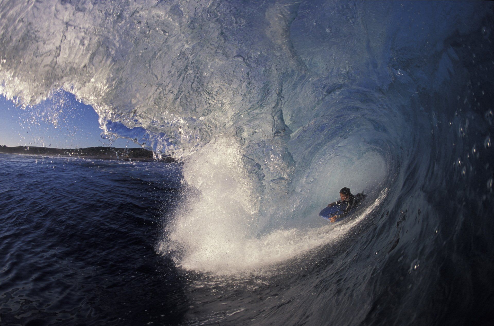 A person is riding a wave in the ocean.