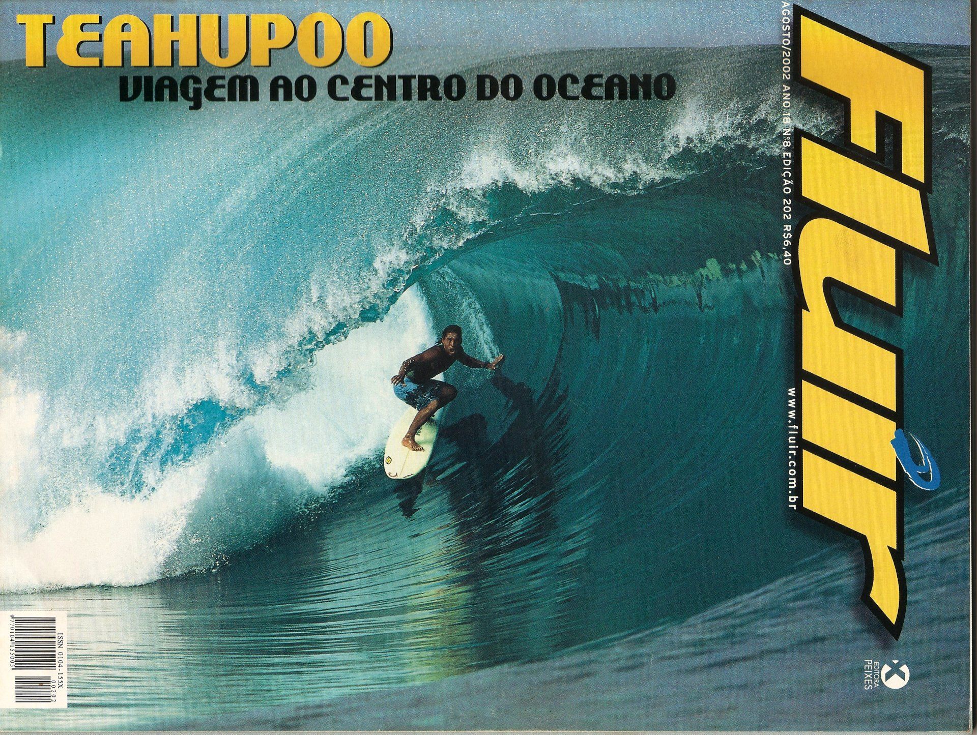 A man on a surfboard is on the cover of a magazine called fluir