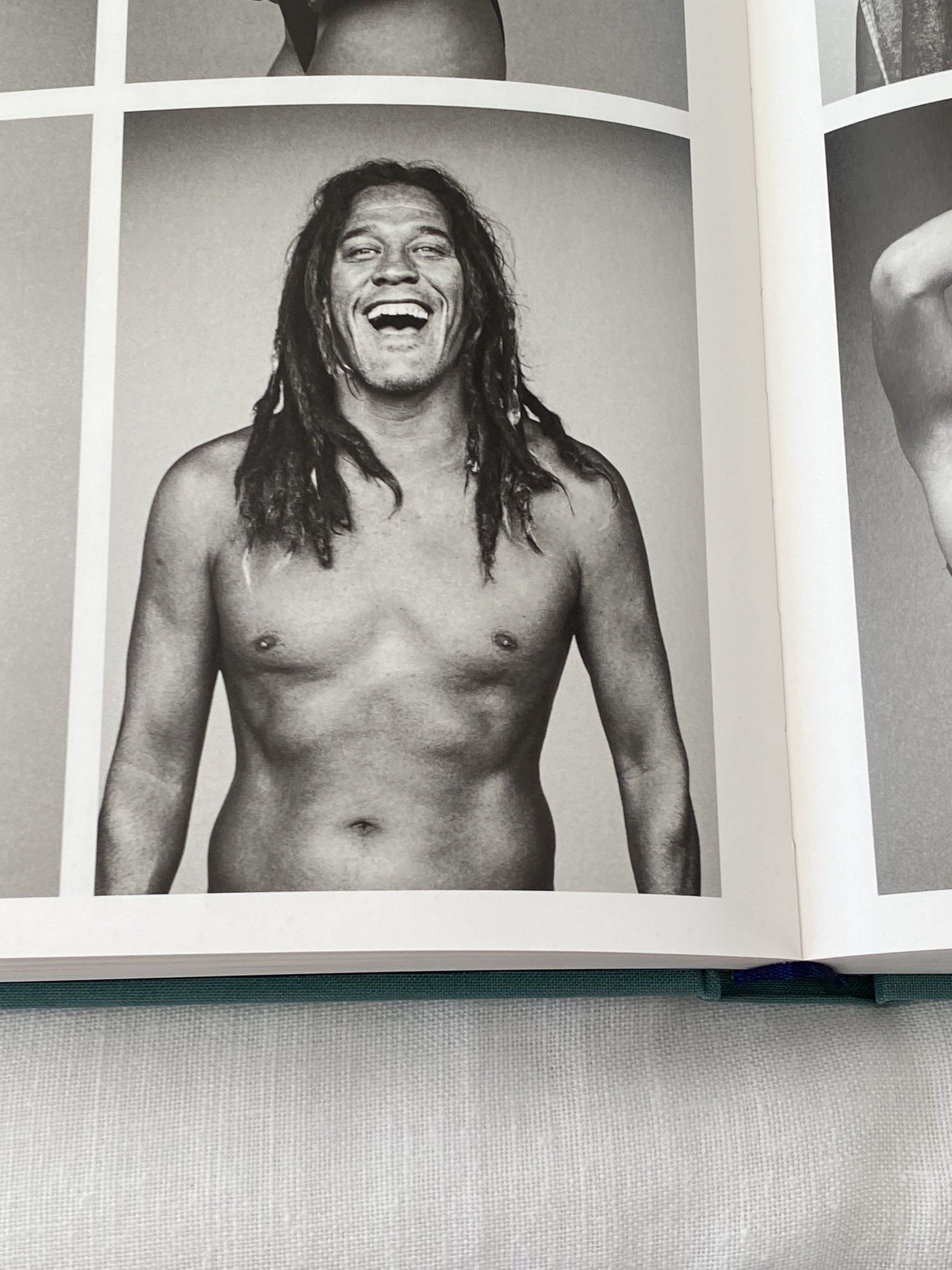 A black and white photo of a shirtless man with long hair