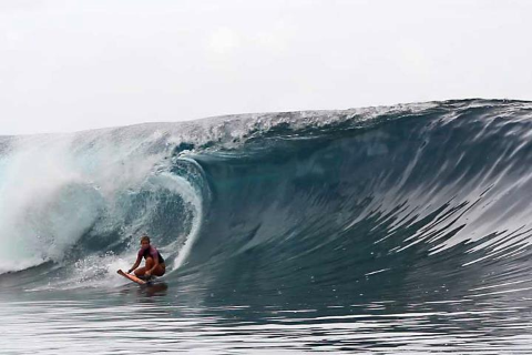 A man is riding a wave on a surfboard in the ocean
