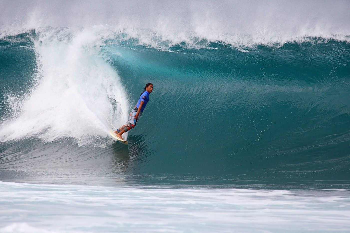 A man is riding a wave on a surfboard in the ocean.