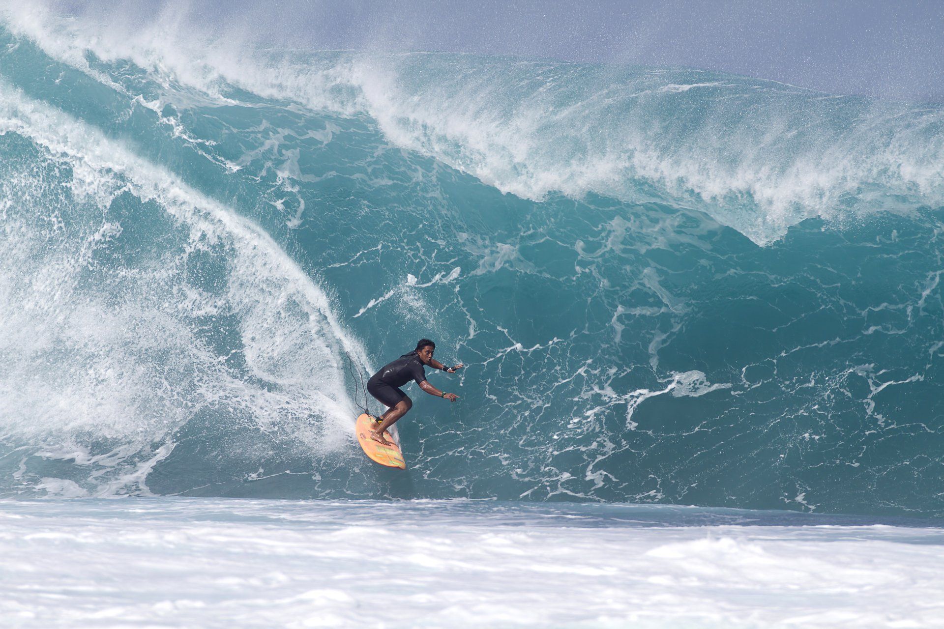 A man is riding a wave on a surfboard in the ocean.