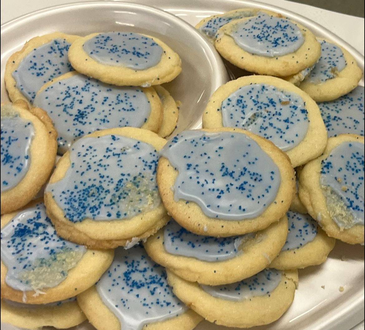 a close up of a wedding cake with white roses and lace .