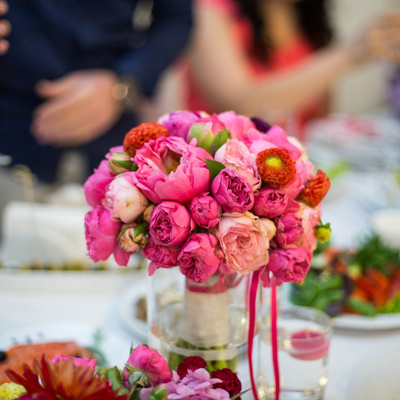 a bouquet of pink flowers in a vase on a table