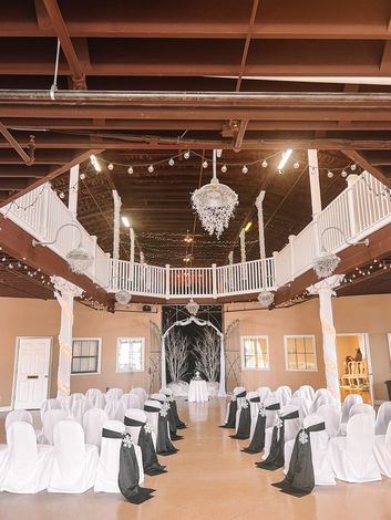 a large room for a wedding ceremony with white chairs and a balcony