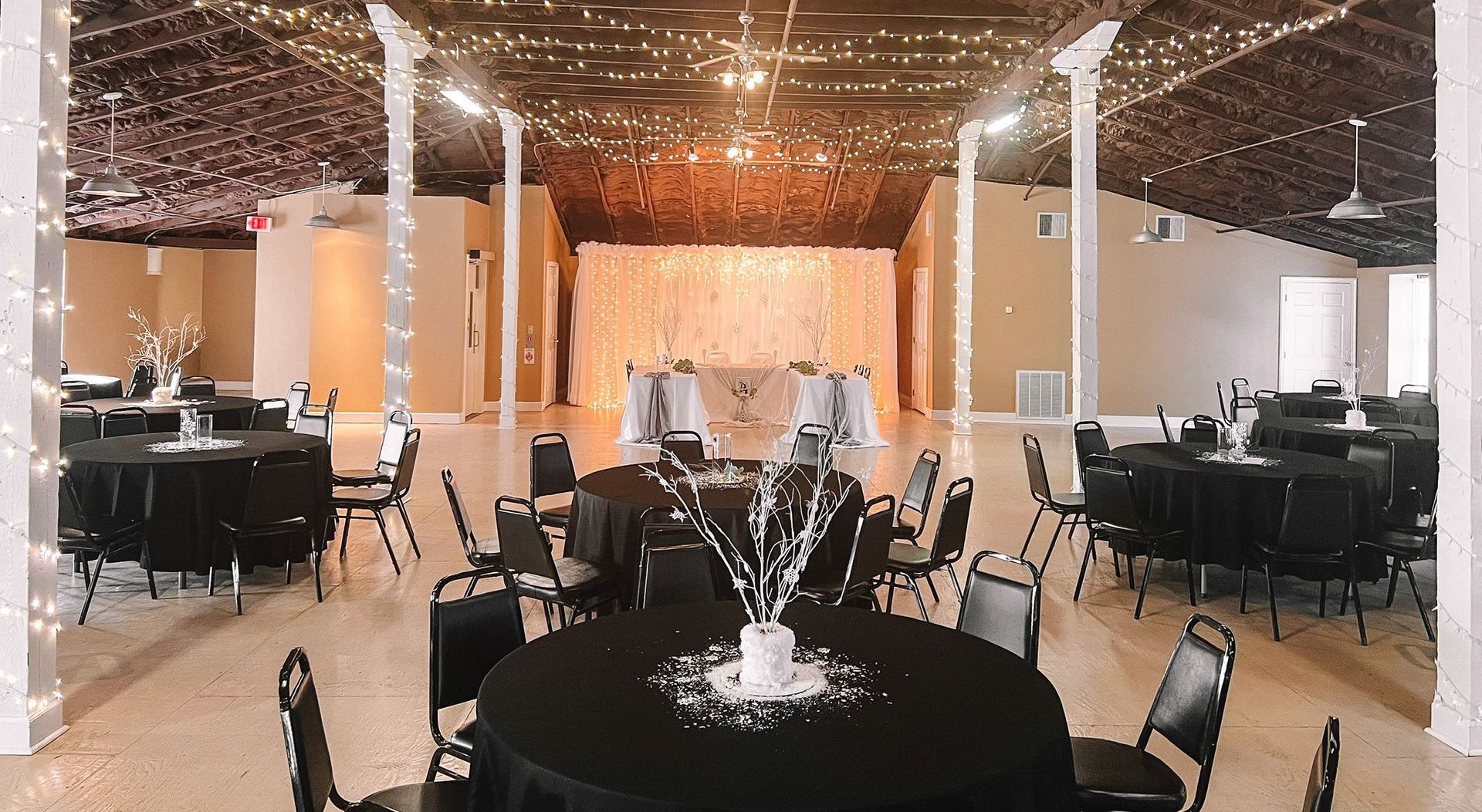 a large room with tables and chairs set up for a wedding reception .