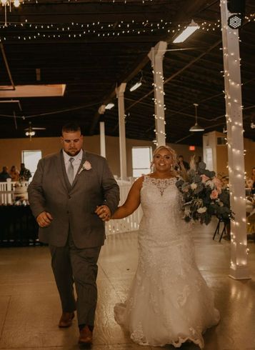 a bride and groom are walking at their wedding reception holding hands