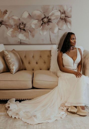 a woman in a wedding dress is sitting on a couch getting ready for her wedding