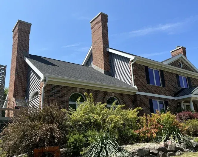 A large brick house with two chimneys on the roof