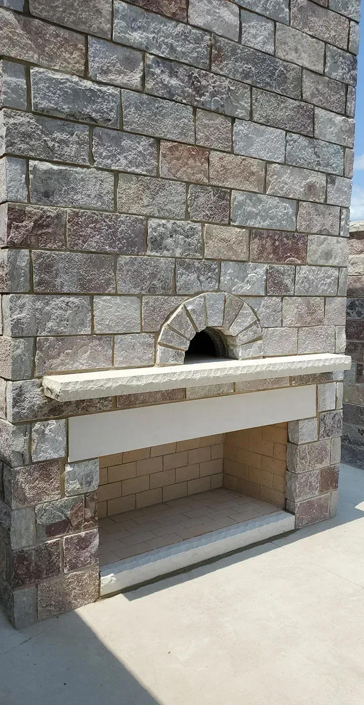 A brick wall with a fireplace in the middle of it.