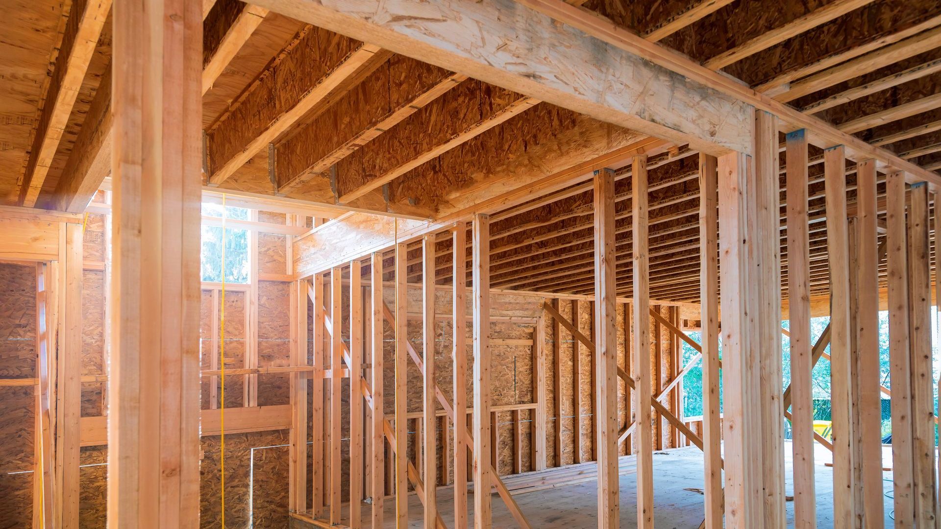 Interior wooden house framing with exposed beams and studs.
