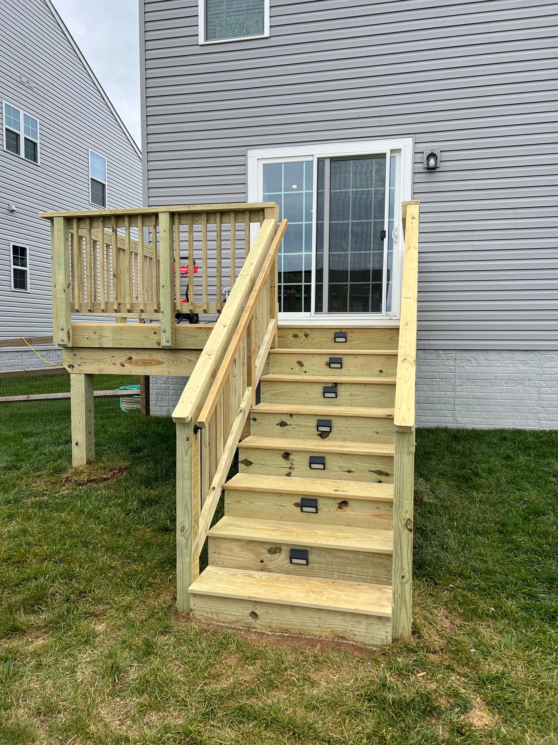 wooden deck and stairs leading to brushed concrete patio
