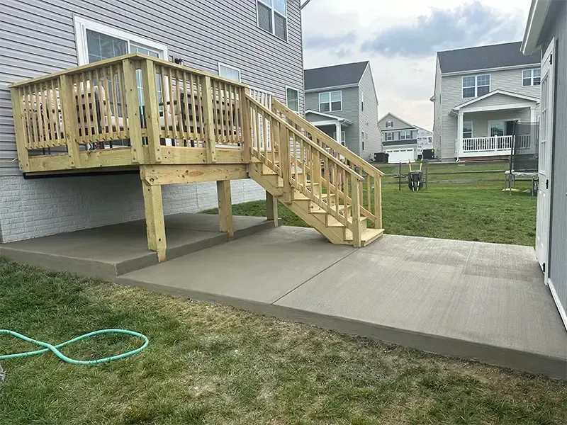 brushed concrete patio with wooden deck above