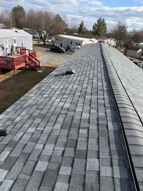 Gray asphalt shingle roof on a mobile home in a sunny, outdoor setting.