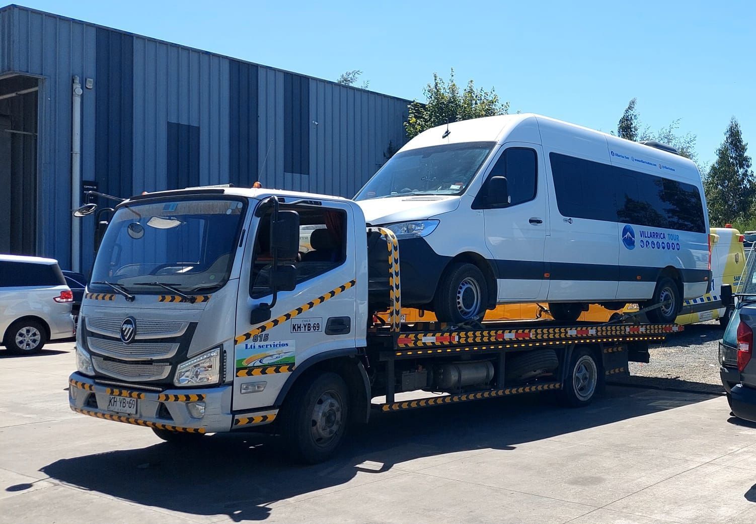 Una grúa está remolcando una camioneta blanca en un estacionamiento.