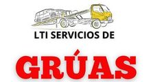 A logo for lti servicios de gruas with a tow truck