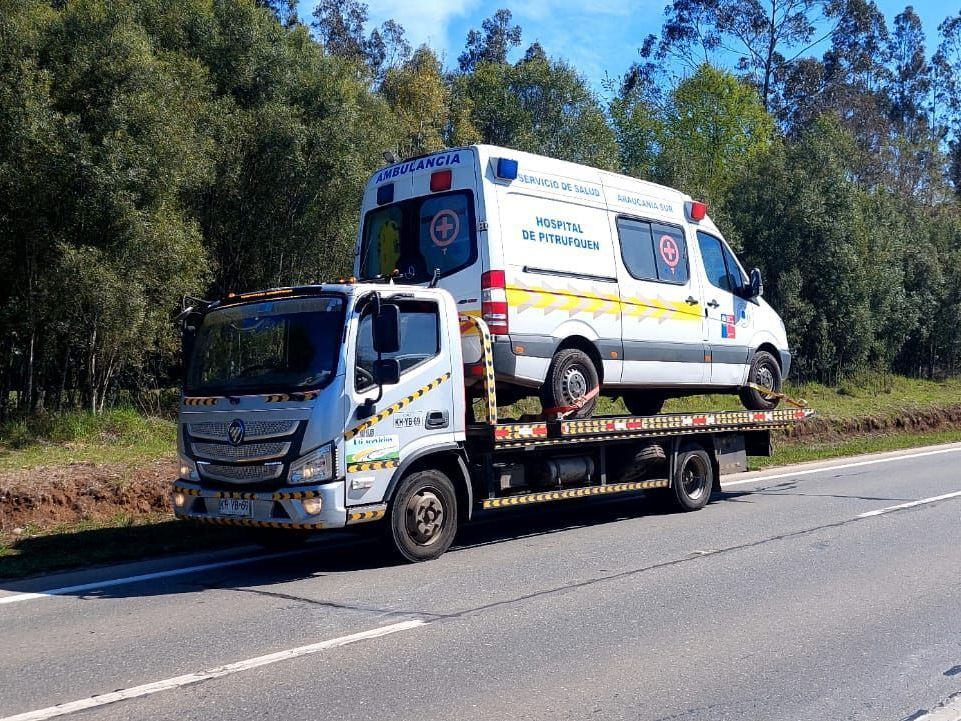 Una ambulancia está sentada encima de una grúa.