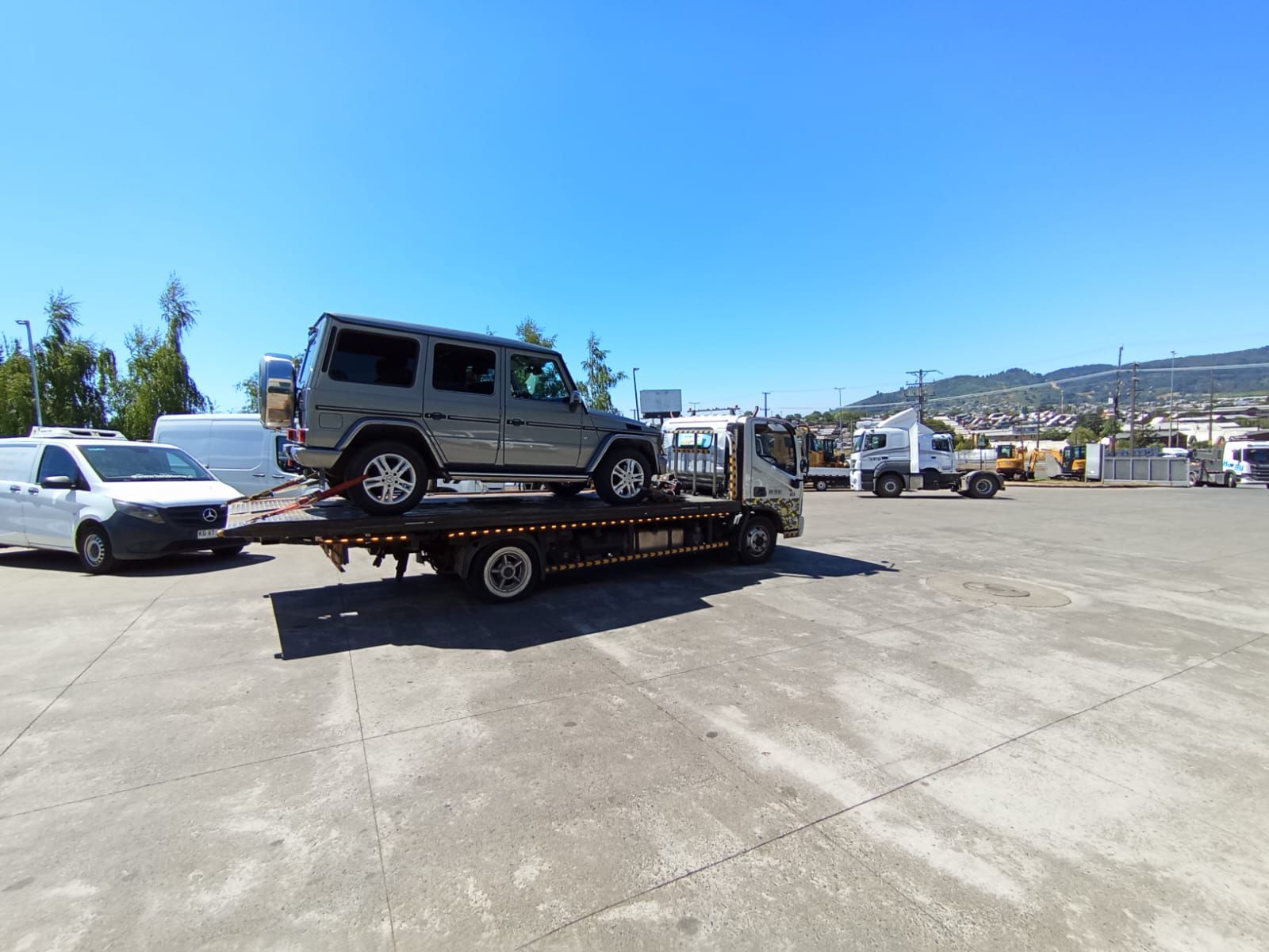 Un coche está siendo remolcado por una grúa en un estacionamiento.