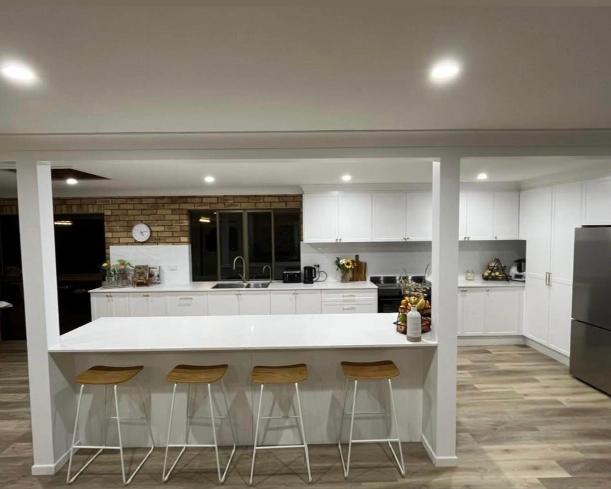 A kitchen with white cabinets , stainless steel appliances , a sink , and a refrigerator.