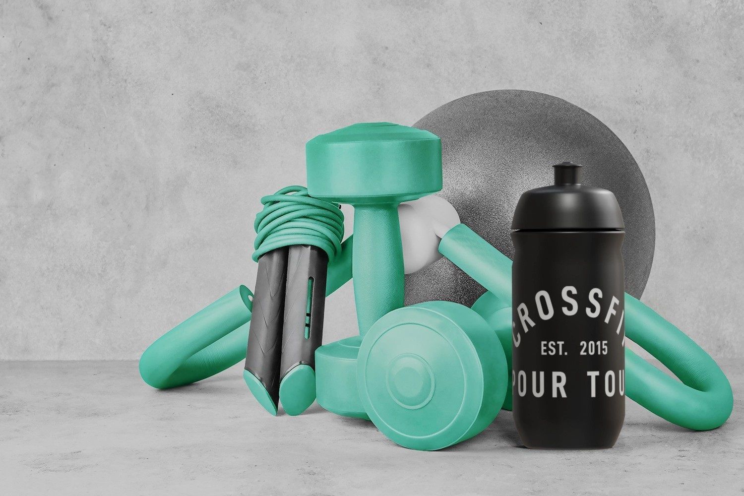 Équipement de fitness : haltères, corde à sauter, ballon d'exercice, bouteille d'eau sur une surface grise.