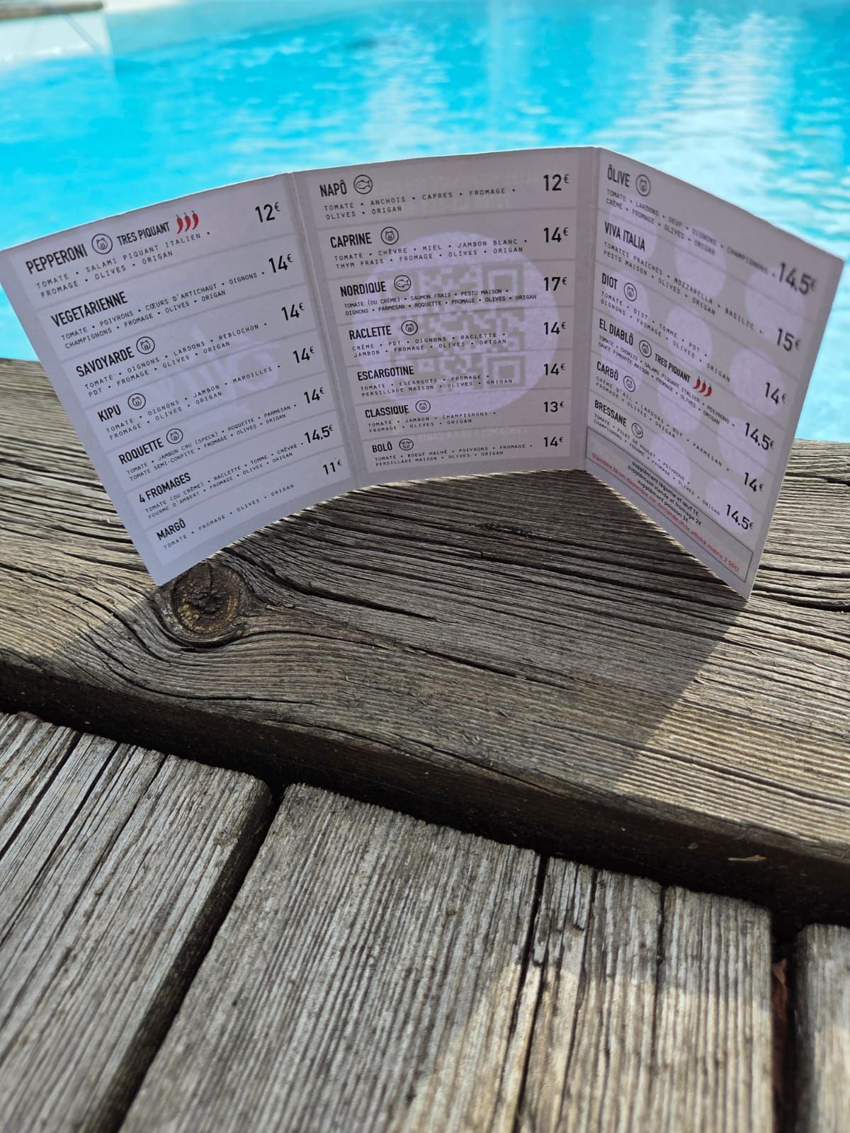 Menu à trois volets sur bois, piscine en arrière-plan.