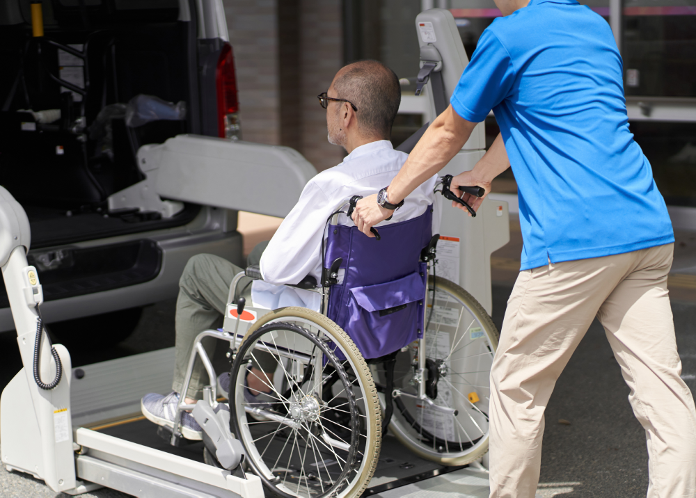 A man is pushing a man in a wheelchair into a van.