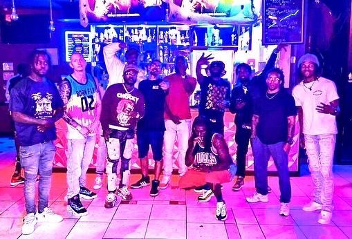 A group of people are posing for a picture in front of a bar.