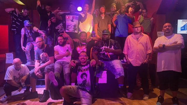 A group of men are posing for a picture in a club.