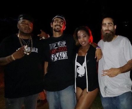 A group of people posing for a picture with one wearing a playboy shirt