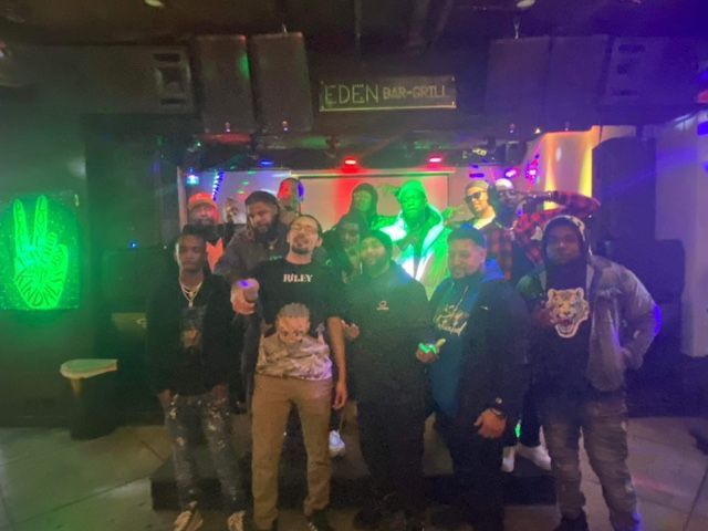 A group of people are posing for a picture in a dark room.