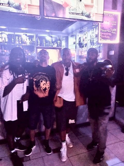 A group of men are posing for a picture in front of a bar