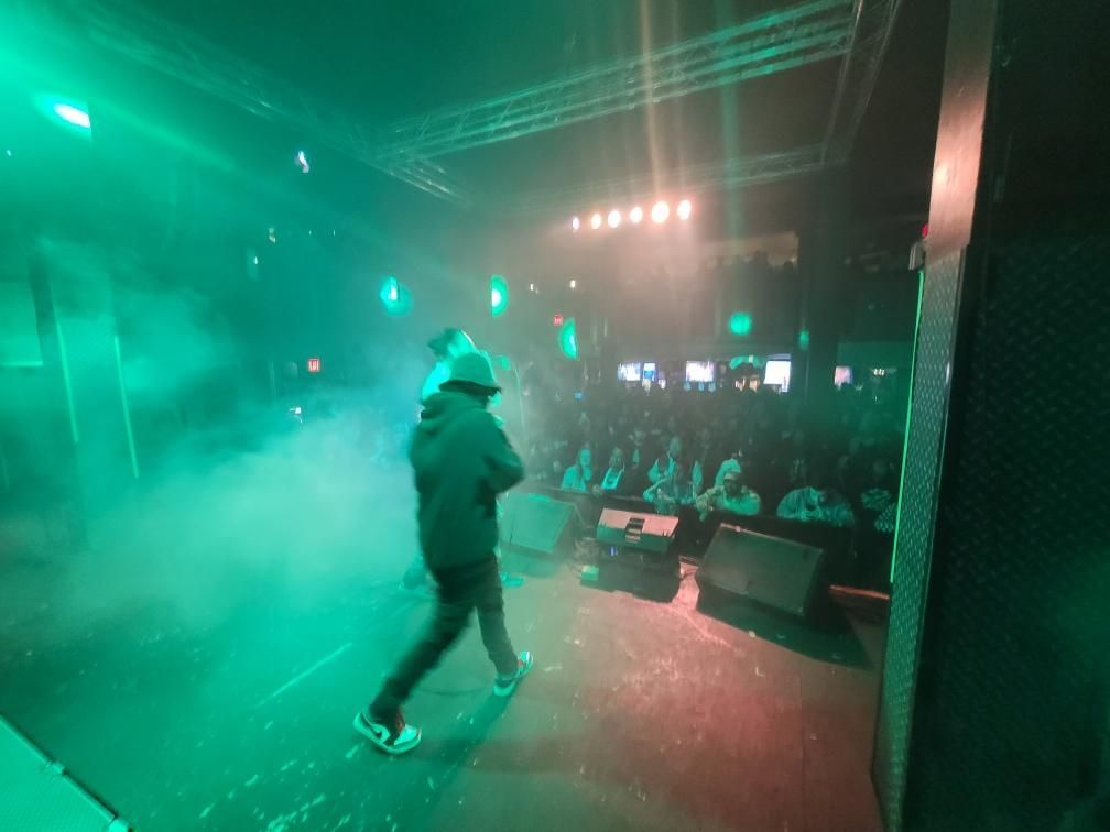 A man is standing on a stage in front of a crowd.