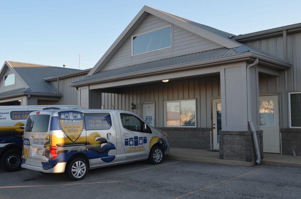 A van with a shield on the side is parked in front of a building