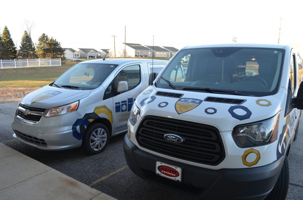 Two vans are parked next to each other in a parking lot
