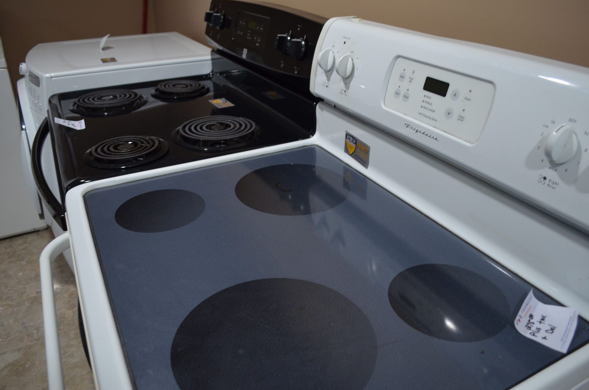 A white stove with a black stove in the background