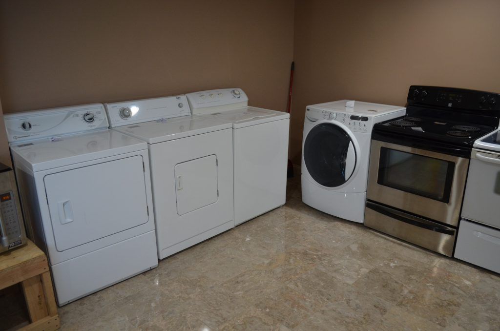 A laundry room with a washer and dryer and a stove