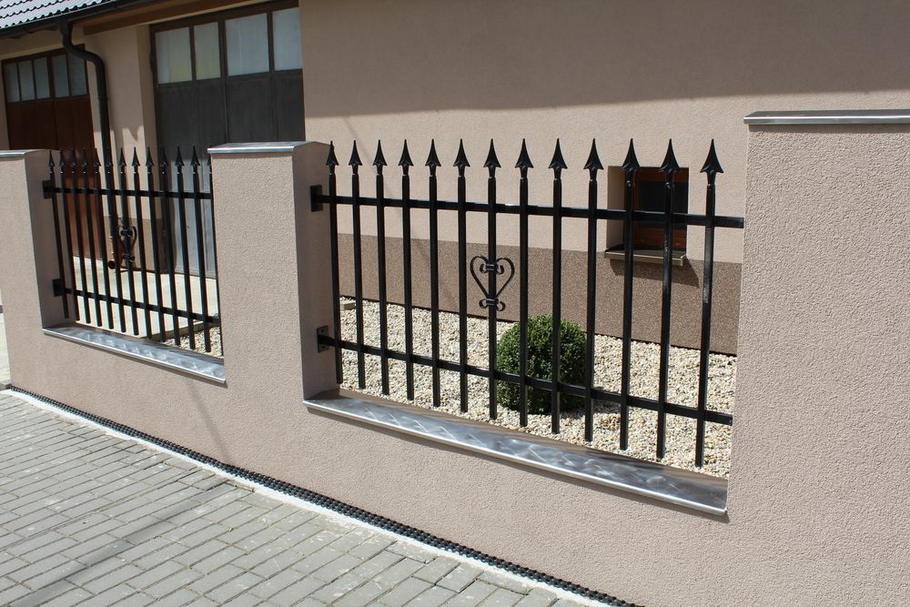 A Wrought Iron Fence Surrounds The Side Of A House — Dubbo Allfence in Dubbo, NSW