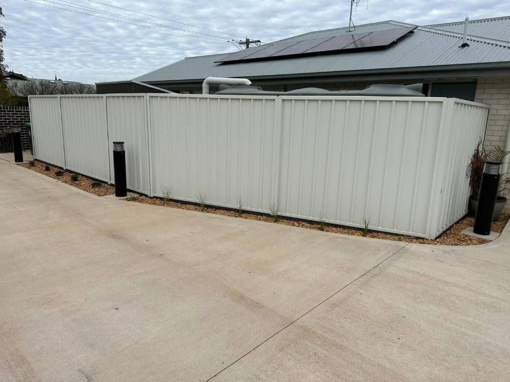A White Fence Is In Front Of A House With Solar Panels On The Roof — Dubbo Allfence in Dubbo, NSW