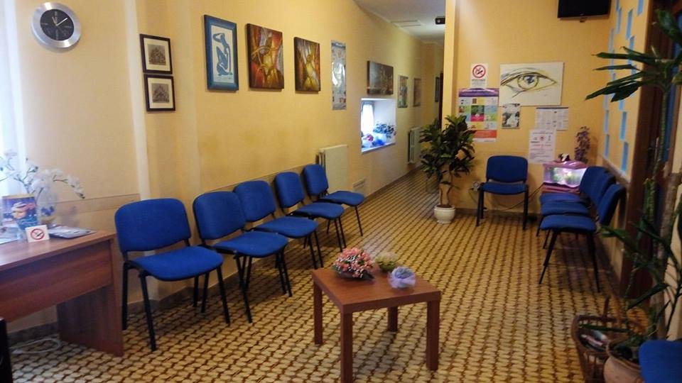 una sala d’attesa con delle sedie blu e un tavolino al centro