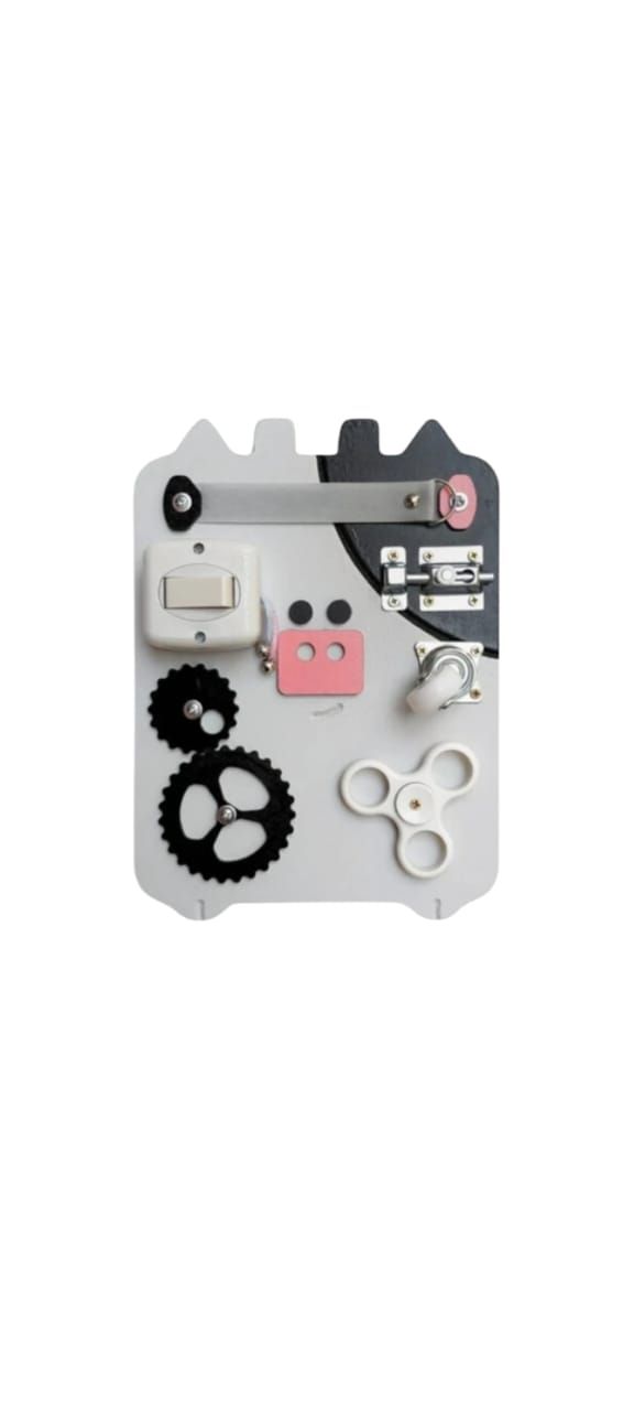 Una pizarra blanca con engranajes amarillos y tijeras sobre ella.