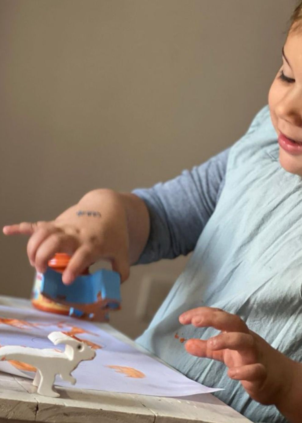 Niño apilando bloques de colores con forma de animales sobre una mesa.