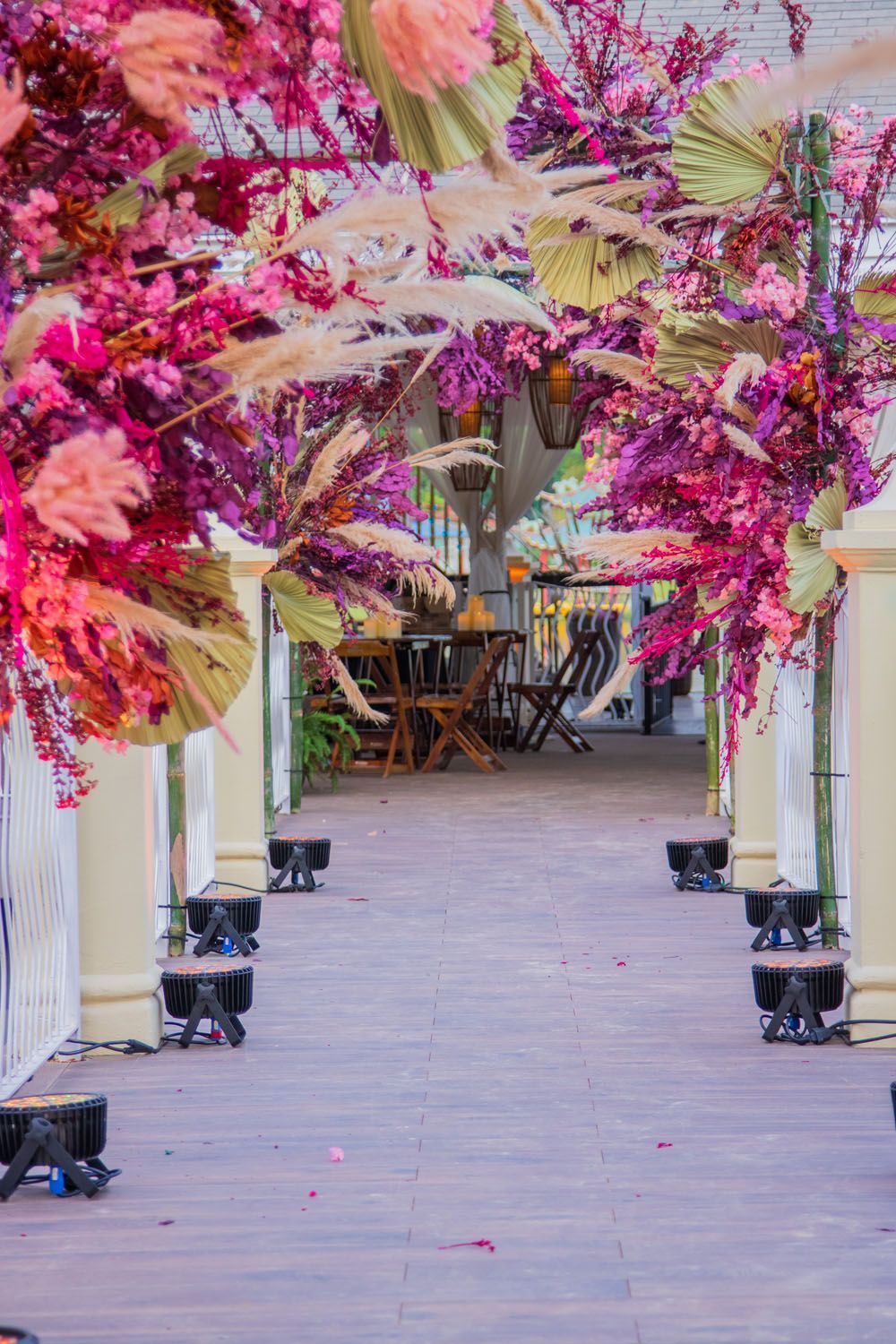 Uma passarela forrada com flores e folhas rosa e roxas.