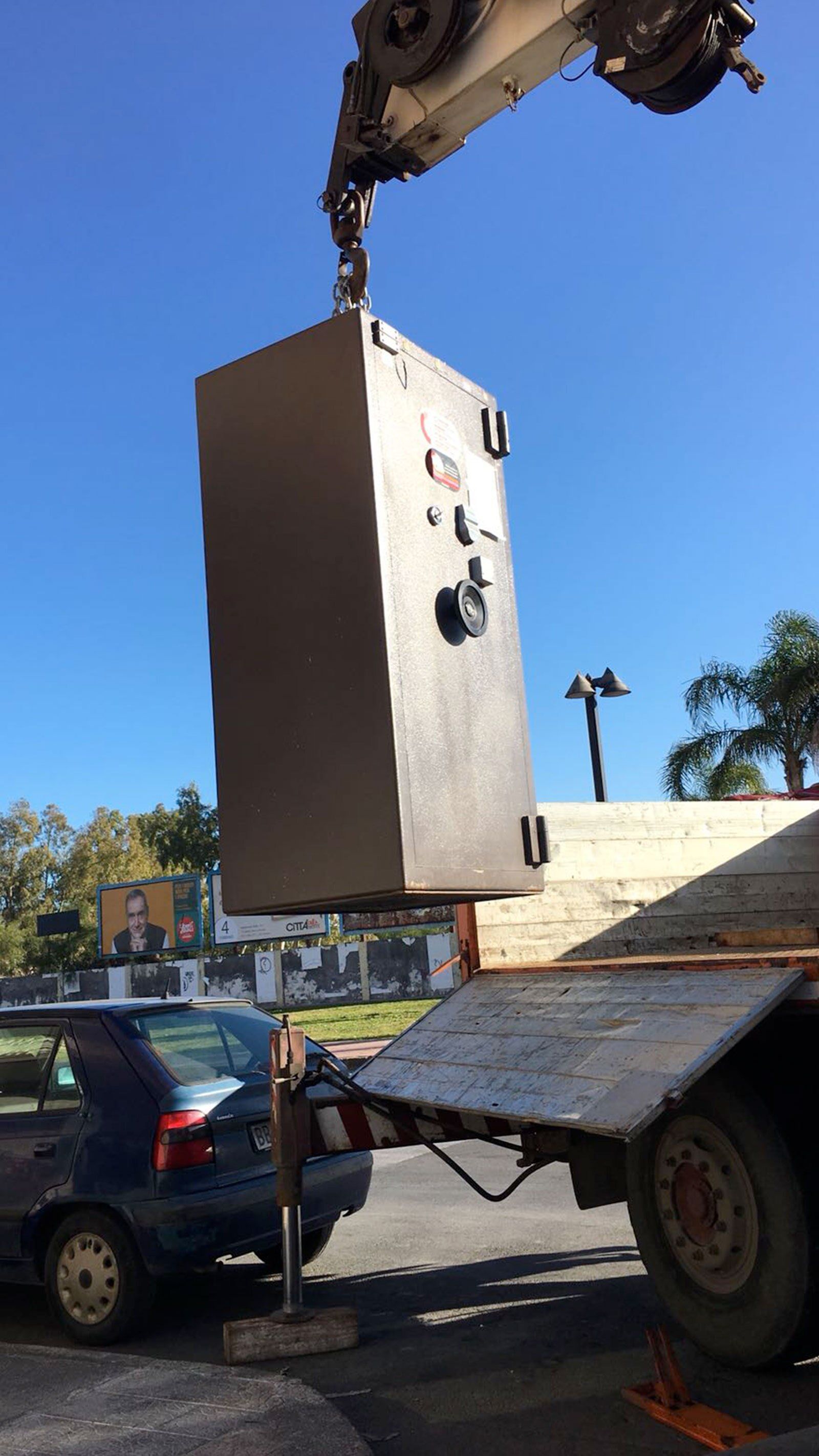 macchina con braccio meccanico mentre solleva una cassaforte