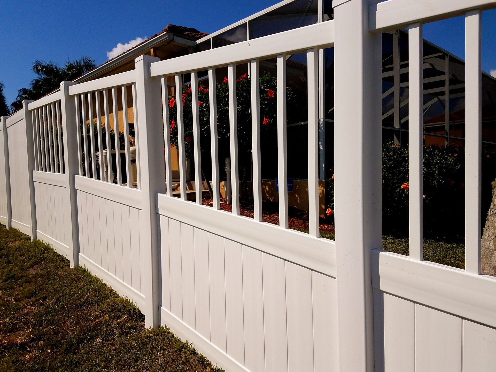 A white fence with a house in the background