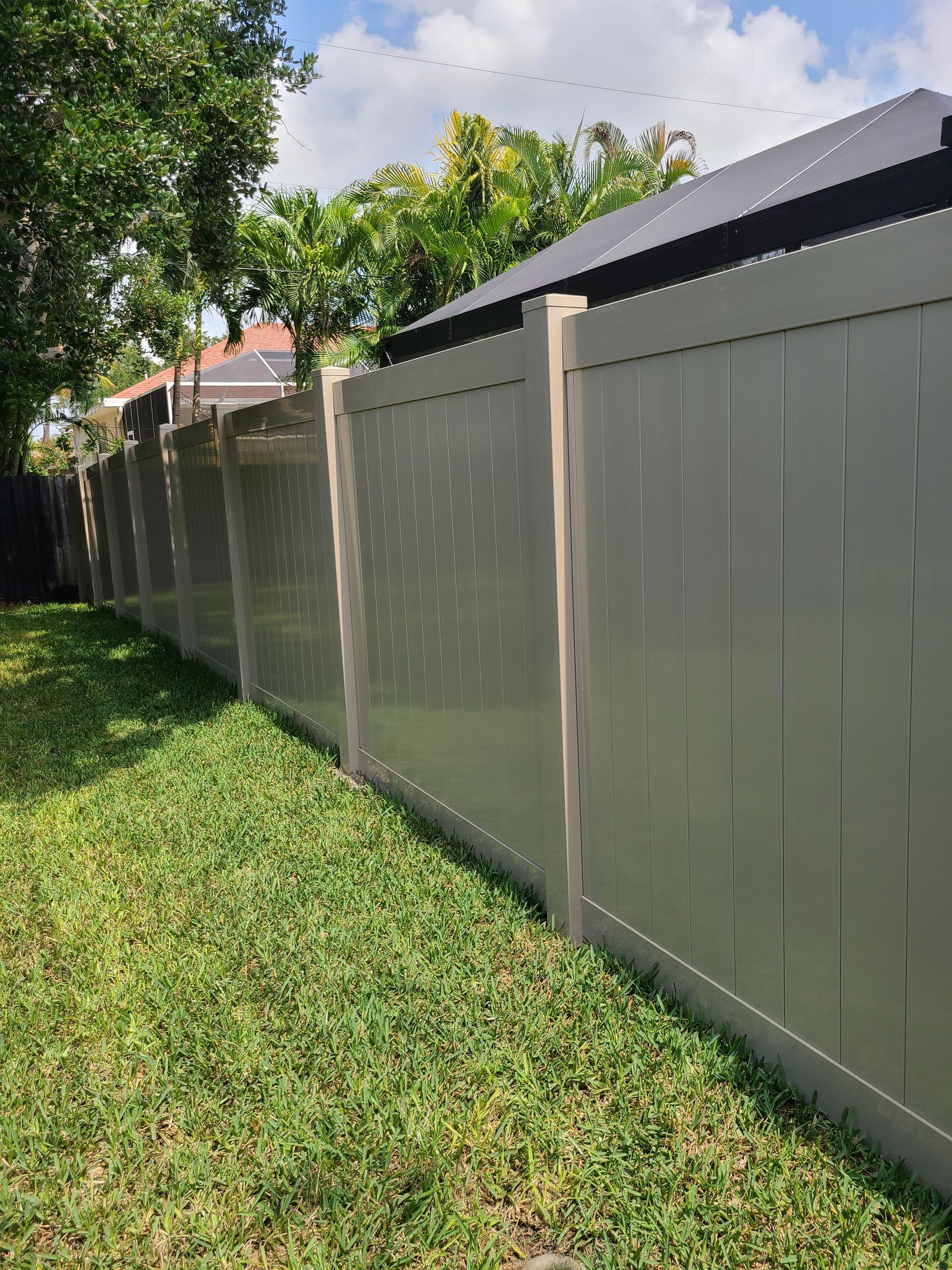 A fence is sitting in the middle of a lush green field.