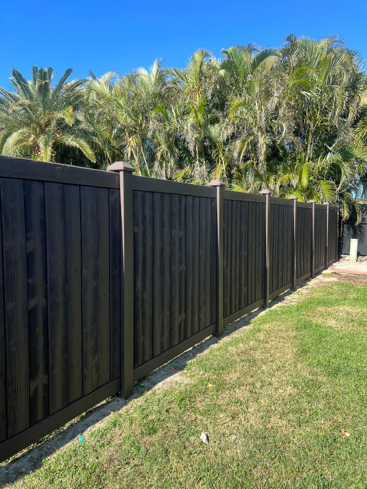 A wooden fence is sitting in the middle of a lush green field.