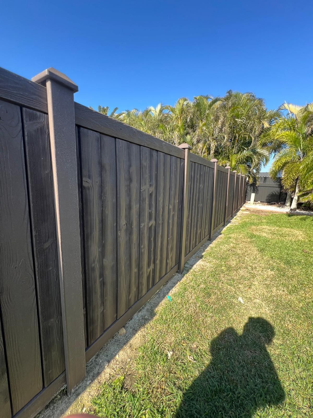 A wooden fence is sitting in the middle of a lush green field.