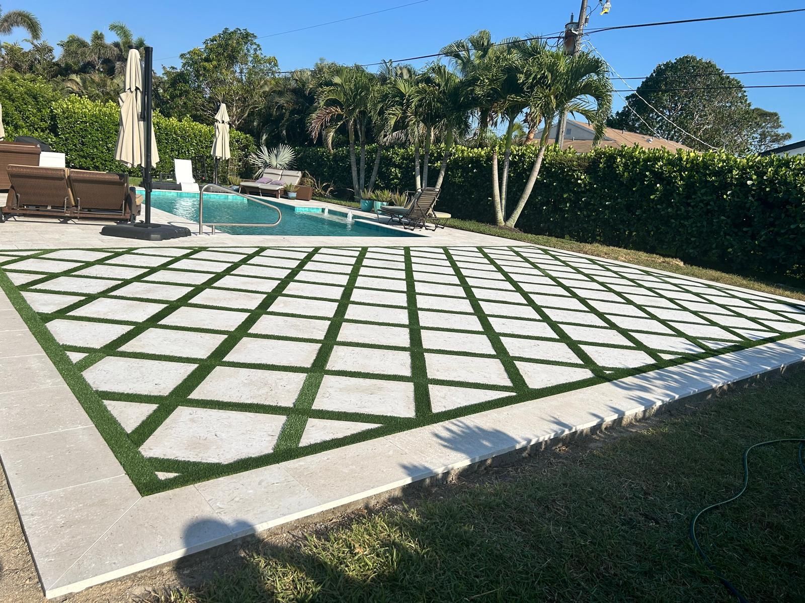 A white fence surrounds a garden with plants and gravel.