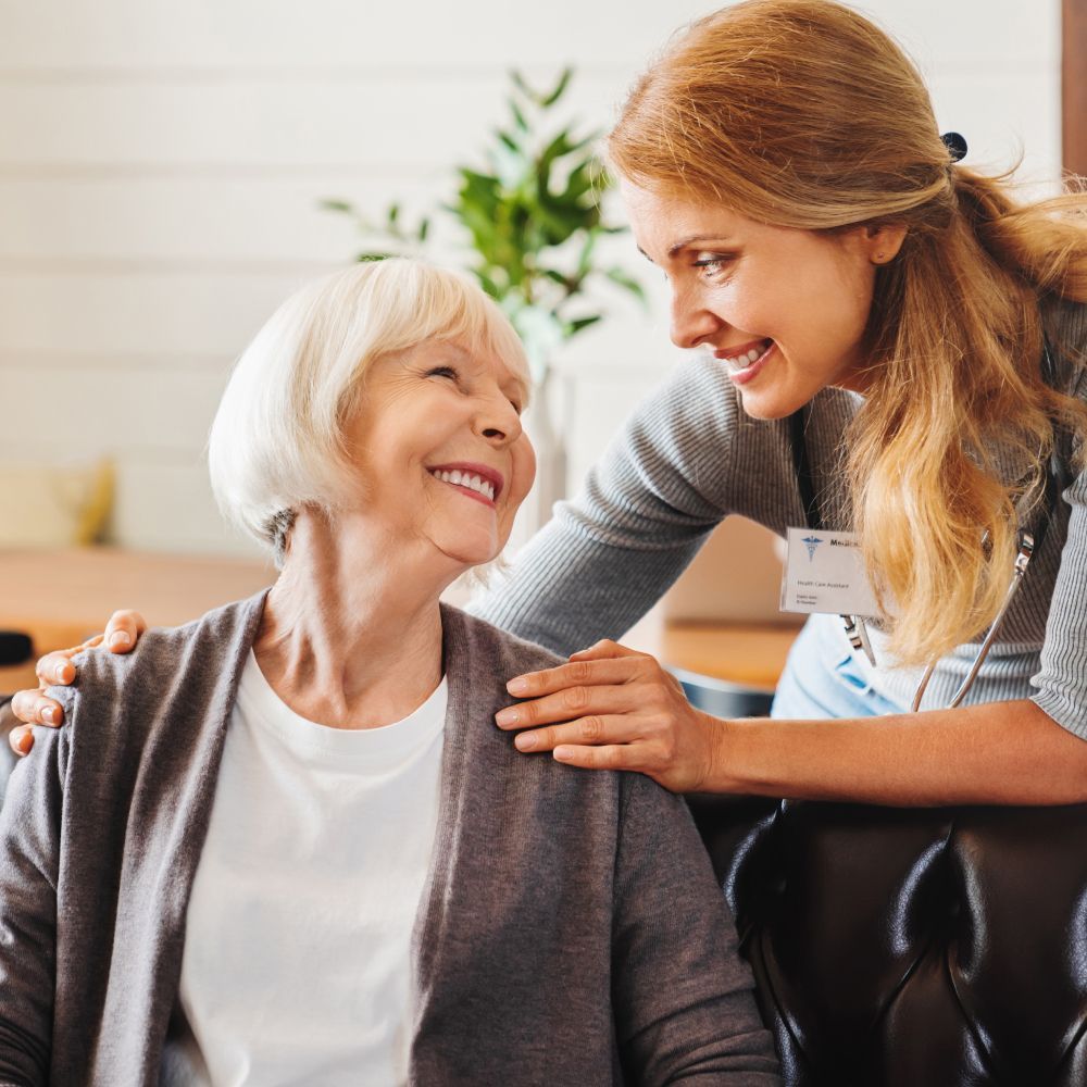 A woman is putting her arm around an older woman 's shoulder.