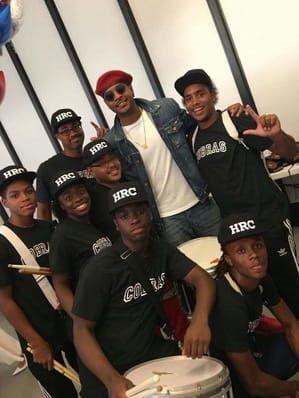 a group of young men are posing for a picture in front of a drum set